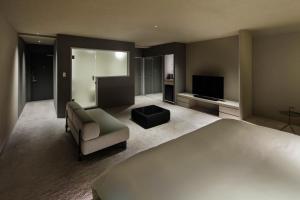 a bedroom with a bed and a couch and a television at The Screen in Kyoto