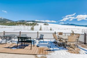 a deck with tables and chairs in the snow at Elk View Lodge in Eagle Nest