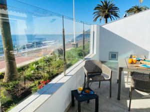 un balcon avec une table et des chaises et une vue sur l'océan dans l'établissement Villa Lucia by SunHousesCanarias with private pool, à San Agustín
