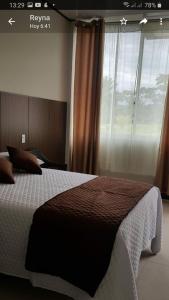 - une chambre avec un grand lit et une fenêtre dans l'établissement Las Bioma's Aqua-Park, à Villa Tunari
