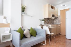 a living room with a couch and a kitchen at Apartamentos Ohana - Edificio Tonillo in Los Cristianos