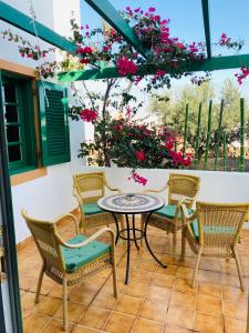 a patio with a table and chairs and flowers at Happiness in Caleta De Fuste