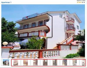 a large white building with balconies and stairs at Apartmani Nina in Crikvenica