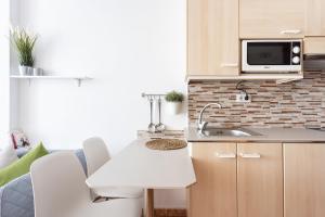 a small kitchen with a sink and a microwave at Apartamentos Ohana - Edificio Tonillo in Los Cristianos