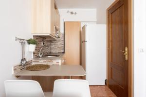 a small kitchen with a table and white appliances at Apartamentos Ohana - Edificio Tonillo in Los Cristianos