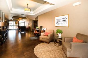 Hawthorn Suites by Wyndham-Oakland/Alameda في ألاميدا: غرفة معيشة مع أريكة وكراسي وطاولة