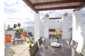 z widokiem na patio ze stołem i krzesłami w obiekcie WintowinRentals Townhouse, Roof Terraze & Pool w mieście Torre de Benagalbón