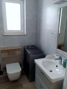 uma casa de banho com um WC e uma janela. em Apartament Rodzinny em Szklarska Poręba