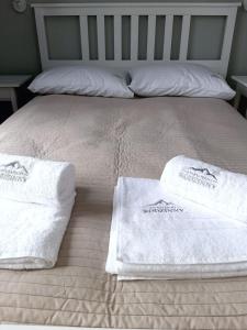 uma cama com duas toalhas e duas almofadas em Apartament Rodzinny em Szklarska Poręba