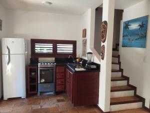 una cocina con nevera y fogones y una escalera en Paraiso Tropical - Casa 7, en Pipa
