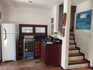 una cucina con frigorifero, piano cottura e scala di Paraiso Tropical - Casa 7 a Pipa