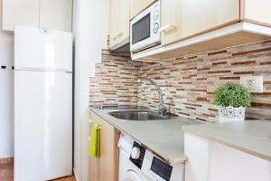 a kitchen with a sink and a white refrigerator at Apartamentos Ohana - Edificio Tonillo in Los Cristianos