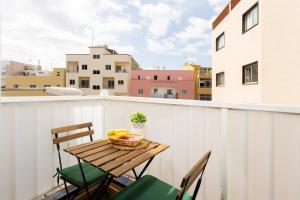 a table with chairs and a basket of fruit on a balcony at Apartamentos Ohana - Edificio Tonillo in Los Cristianos