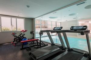 a gym with two treadmills and a swimming pool at Triplex con terraza única a 50 mts del mar in Carilo