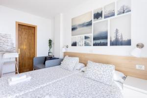 a bedroom with a bed and some pictures on the wall at Apartamentos Ohana - Edificio Tonillo in Los Cristianos