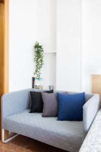 a couch with blue pillows in a living room at Apartamentos Ohana - Edificio Tonillo in Los Cristianos