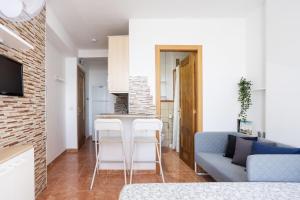 a kitchen and living room with a couch and a table at Apartamentos Ohana - Edificio Tonillo in Los Cristianos