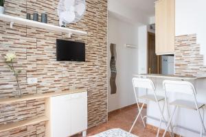 a kitchen with white cabinets and a brick wall at Apartamentos Ohana - Edificio Tonillo in Los Cristianos