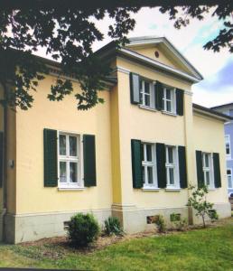 Una casa amarilla con persianas verdes. en Haus Berlin, en Hagen