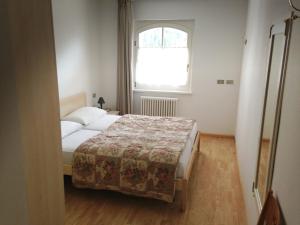 Habitación pequeña con cama y ventana en Appartamento Col Val di Fassa con giardino BAGNI RINNOVATI 2023 en Campitello di Fassa