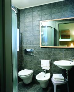 a bathroom with a sink and a toilet and a mirror at Meridiana Country Hotel in Calenzano