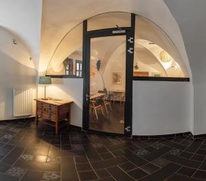 a room with an arched doorway with a table and chairs at Penzion THIR in Tábor