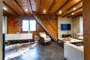 a living room with a wooden ceiling and a staircase at Les Myrtilles, classé 5 étoiles in Metzeral