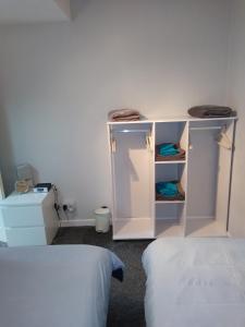 a room with two beds and a white cabinet at Flat by the sea in Paignton +3 photos
