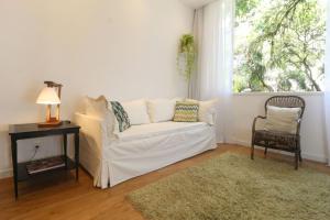 Leblon House IV في ريو دي جانيرو: غرفة معيشة مع أريكة بيضاء ونافذة