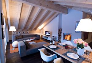 a living room with a couch and a table at Chalet Altesse - Premium Apartments in Zermatt