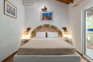 a bedroom with a large bed and a window at Elefteria Apts & Suites in Kolymbia
