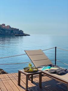 une chaise et une table sur un quai à côté de l'eau dans l'établissement Apartments Eneida, à Ulcinj