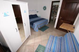 a bedroom with two beds and a blue wall at B&B Acquamarina Villasimius in Villasimius