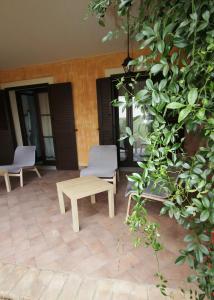 een patio met 2 stoelen, een bank en een tafel bij B&B Acquamarina Villasimius in Villasimius