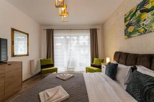 a bedroom with a bed and a tv and a couch at All Homes by Nati in Braşov