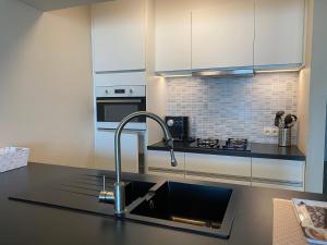 a kitchen with a sink and a counter top at Gezellig appartement met zeezicht Middelkerke in Middelkerke