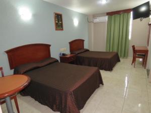 a hotel room with two beds and a table at Hotel San Juan Centro in Villahermosa