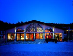 a building with a lit up facade at night at Meridiana Country Hotel in Calenzano