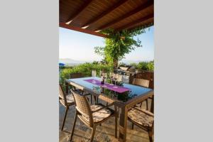 einen Tisch und Stühle auf einer Terrasse mit Aussicht in der Unterkunft Villa Elia with pool, Yurt and sea views in Kos-Stadt