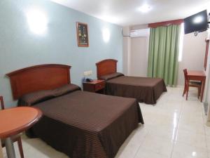 a hotel room with two beds and a table at Hotel San Juan Centro in Villahermosa