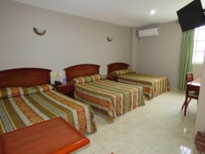 pokój hotelowy z 3 łóżkami i stołem w obiekcie Hotel San Juan Centro w mieście Villahermosa