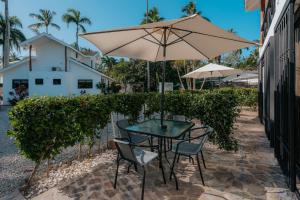 Condo Hotel Playa Las Ballenas في لاس تاريناس: طاولة وكراسي مع مظلة على الفناء