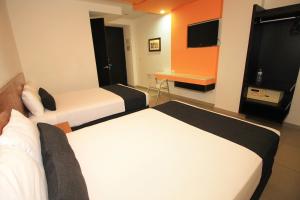 Cette chambre comprend deux lits et un bureau. dans l'établissement Nu Hotel, à Veracruz