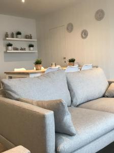 - un salon avec un canapé et une table avec des chaises dans l'établissement Villa Capricia, à Nieuport