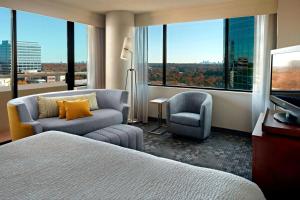 um quarto de hotel com uma cama e uma cadeira e uma televisão em Sonesta Select Atlanta Cumberland Galleria em Atlanta