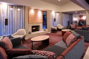 a living room with couches and a fireplace at Sonesta Select Kansas City Airport Tiffany Springs in Kansas City
