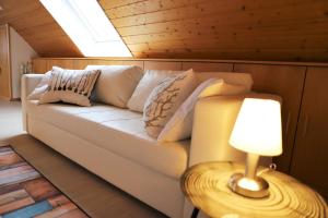 a couch with pillows on it in a room with a lamp at Gästehaus Willaringen in Rickenbach