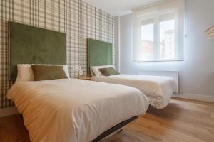 1 dormitorio con 2 camas y ventana en Old bilbao Con Vistas a la Ria by Urban Hosts, en Bilbao