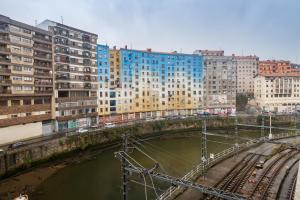 a bridge over a river in a city with buildings at Old bilbao Con Vistas a la Ria by Urban Hosts in Bilbao