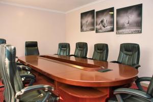 una sala de conferencias con mesa y sillas en Aberdare Prestige & Royal Cottages en Nanyuki